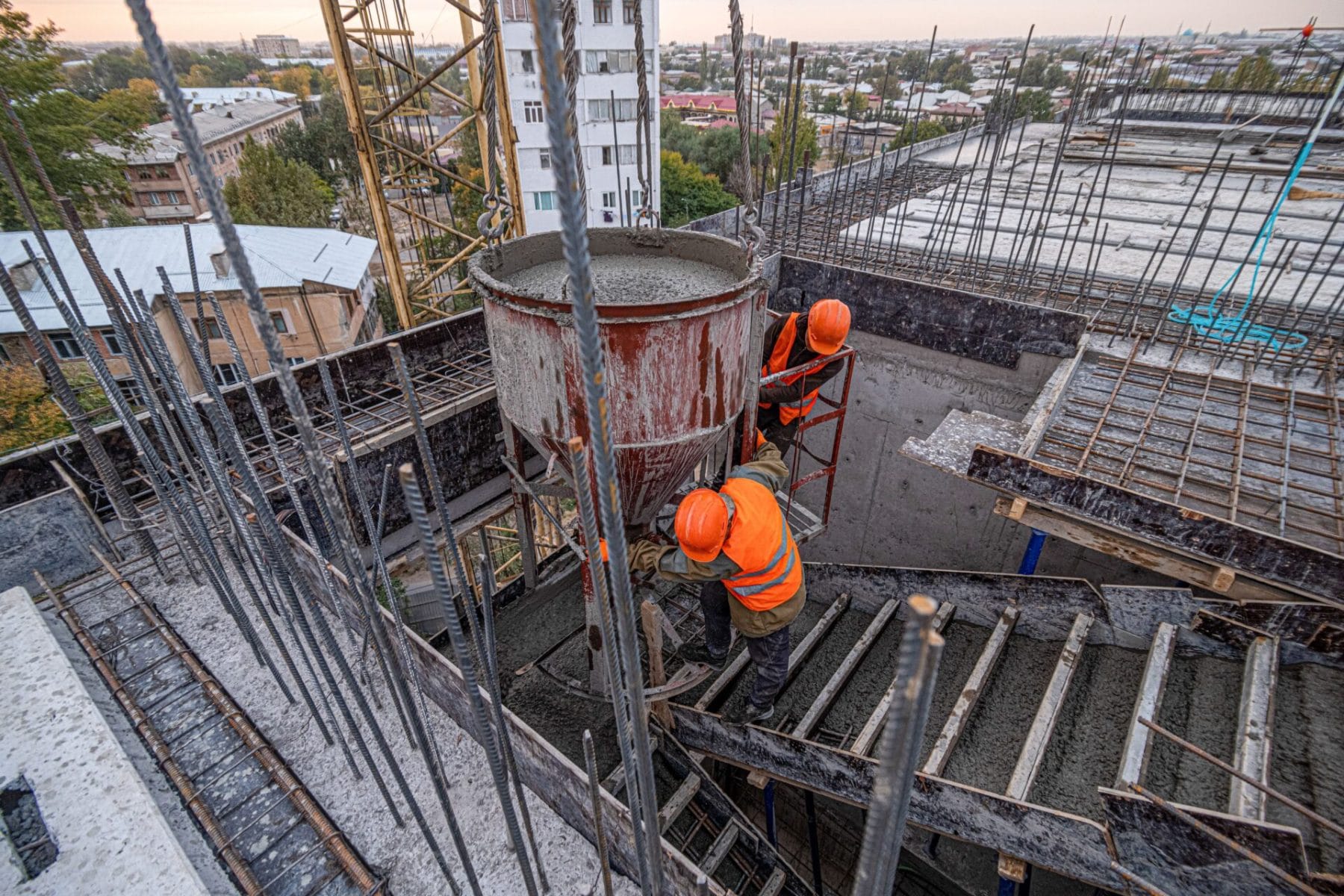 Workers on a building infrastructure roof with machinery and tools